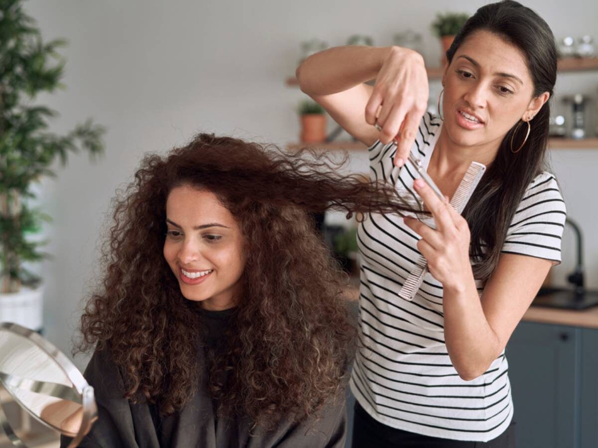 Someone with extremely curly hair getting their haircut while their hair is dry